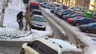 Людина у формі штовхає велосипедиста