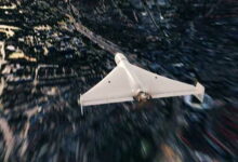 Білий БПЛА летить над чорною землею