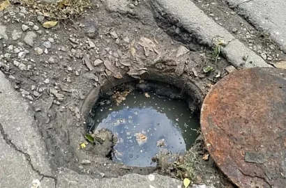 Цегла, металеві листи та предмет, схожий на пластиковий стіл, над каналізаційним колодязем на Океанівській у Миколаєві