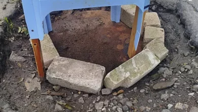 Цегла, металеві листи та предмет, схожий на пластиковий стіл, над каналізаційним колодязем на Океанівській у Миколаєві